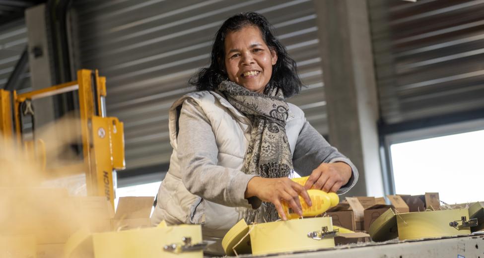 Afbeelding: vrouw aan werktafel pakt dozen in