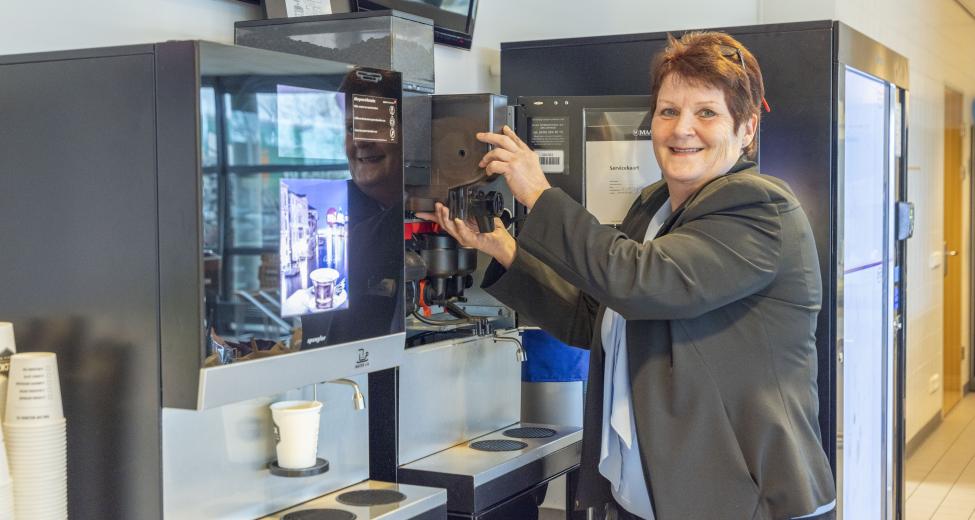 Afbeelding: vrouw bij koffieapparaat