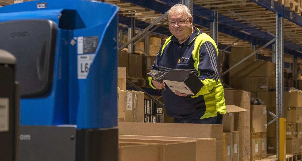 afbeelding man in magazijn met dozen