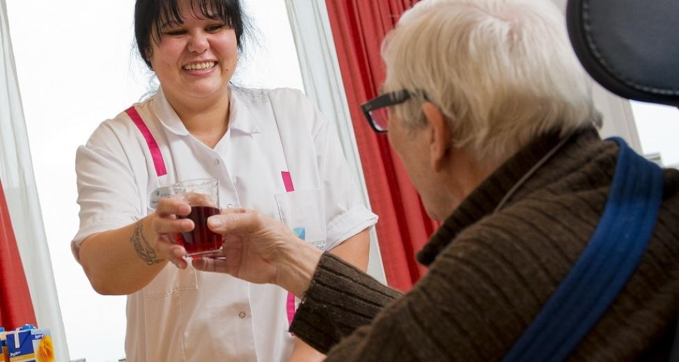 Afbeelding: vrouw geeft glas aan man